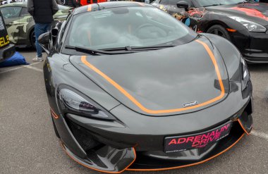 McLaren 570S, turuncu aksanlı gri bir süper araba, günlük kullanıma odaklanmış lüks bir spor araba olarak bilinir.