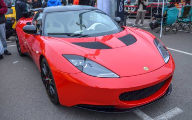Kırmızı çevik İngiliz orta motorlu spor otomobil Lotus Evora hafif gövdesi, aerodinamik tasarımı, olağanüstü kullanım ve dengesi ile ünlüdür.