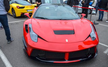 Vibrant kırmızı Ferrari 458 Italia spor araba, çarpıcı bir Prior Design geniş gövde aerodinamik kiti ile modifiye, açık hava araba etkinliği park edilir