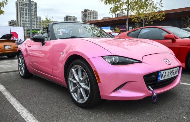 Özel pembe dördüncü nesil (ND) Mazda MX-5 Miata yumuşak üstüyle, parlak Kodo tasarım elemanlarıyla tanımlanabilir