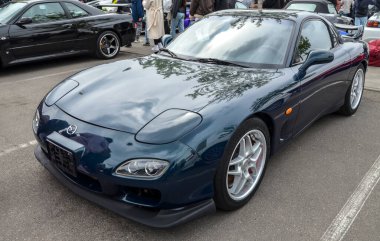 Koyu mavi Mazda RX-7 (FD), organik, zamansız tasarımıyla bilinen 1990 'ların en güzel ve teknik olarak en gelişmiş spor arabalarından biri olarak kutlanır.