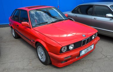 Kırmızı BMW E30, sıklıkla klasik BMW olarak kabul edilir, E30 kusursuz kullanım, sürücü merkezli tasarım ve dengeli orantıları ile kutlanır.