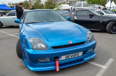 Canlı mavi, yüksek modifiyeli Honda Prelude coupe VTEC motoru ve 4WS sistemi gibi mühendislik maharetiyle bilinir.