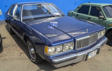 Donanma mavisi 1989 Mercury Grand Marquis tam boy lüks sedan. Geleneksel kutu tasarımı ve klasik Amerikan tasarımı ile retro araba etkinliğine park edilmiş.