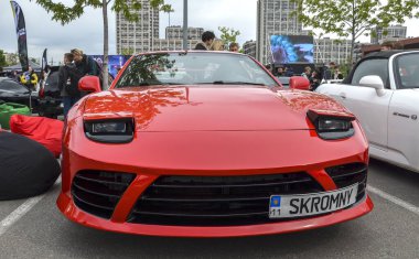 Çarpıcı kırmızı Mitsubishi 3000GT, efsanevi Japon spor arabası ikonik farlar, yontulmuş ön fasya ve düşük profilli duruş içeriyor.