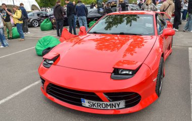 Çarpıcı kırmızı Mitsubishi 3000GT, efsanevi Japon spor arabası ikonik farlar, yontulmuş ön fasya ve düşük profilli duruş içeriyor.