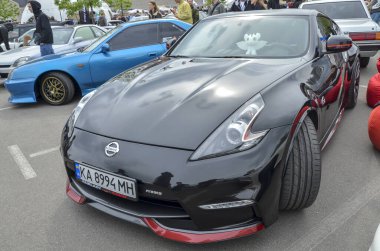 Gösterişli, özelleştirilmiş siyah Nissan 370Z Nismo agresif aerodinamik vücut kiti ve kırmızı aksanlı performans odaklı tasarımı.