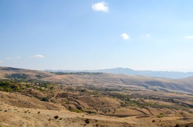 Ermenistan 'ın Kotayk bölgesindeki Charents Kemeri yakınlarındaki kayan kahverengi tepeler ve derin vadilerin yer aldığı engin, kurak dağ manzarası