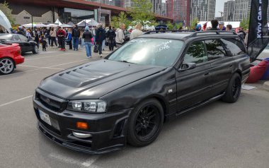 Black Nissan Stagea, yüksek seyahat performansını büyük, kullanıcı dostu bagaj alanıyla birleştiren ayırt edici bir station wagon.