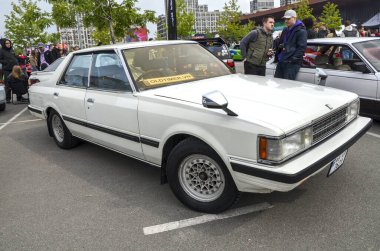 Beyaz 1983 model Toyota Cresta orta boy lüks bir sedan olarak tanıtıldı ve lüks tasarımı ile tanındı.