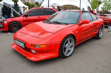 Kırmızı 1991 Toyota MR2, orta motor yapısı, keskin stili ve çevik kullanımıyla tanınıyor. 1990 'lardaki JDM spor araba sahnesinin sevilen bir ikonu.