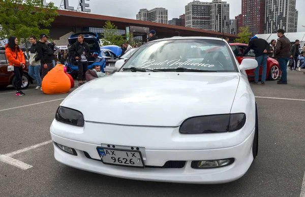 Beyaz Mazda MX-6, gösterişli, aerodinamik tasarımı ve rafine sürüş dinamikleriyle tanınan önden çekişli bir spor coupe.