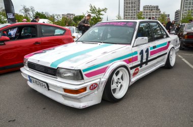 1987 model beyaz, yarış çizgili Nissan Bluebird, Avrupa ve Japon pazarları için tasarlanmış önden çekişli, özel yapım bir özel yapım otomobildir.