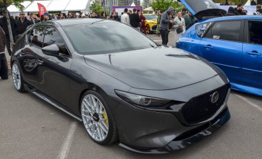 Dördüncü nesil koyu gri Mazda 3 (BP) hatchback modern araba kültüründe popüler olan belirli bir estetik cazibe için modifiye edildi