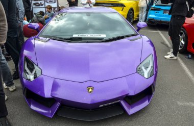Mor Lamborghini Aventador, keskin, görünmez avcı uçağı tasarımı ve yüksek devirli, doğal emilimli V12 motoruyla karakterize edilen bir sancak gemisi orta motor süperarabasıdır.