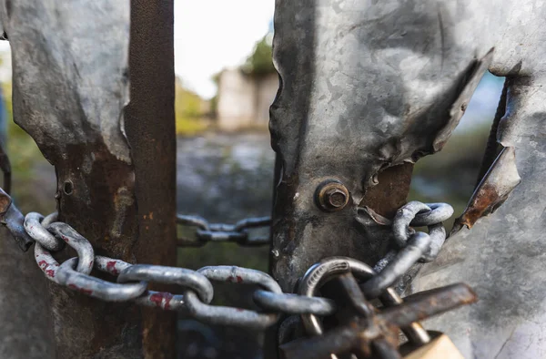 Chains to freedom, old and cut steel door with chains and padlock