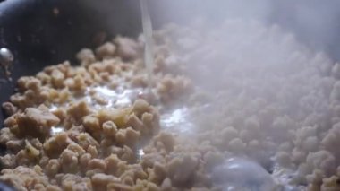 Ev yapımı et kroketleri için geleneksel beşamel hazırlama: süt, soğan, kıymalı İber domuzu ve hindistan cevizi. 4K yüksek çözünürlük, düzgün hareketler.