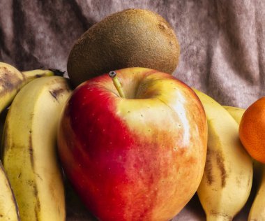 Taze meyve, kırmızı elma, kivi, kanarya muzları ve limon sahnesi..