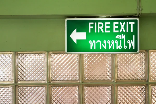 Green emergency fire exit sign showing the way to escape.