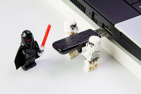 Lego Star Wars Stormtrooper plug the flash drive into notebook . — стоковое фото