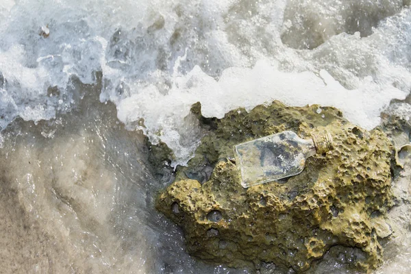 Lege glazen fles aangespoeld als afval op een strand, vuilnis op b — Stockfoto