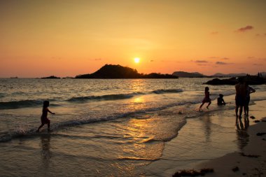 Mutlu çocuk sahilde günbatımı anda oynamak