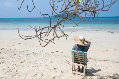 Bir yaz günü beac, zevk bir plaj sandalyesi üzerinde oturan kadın