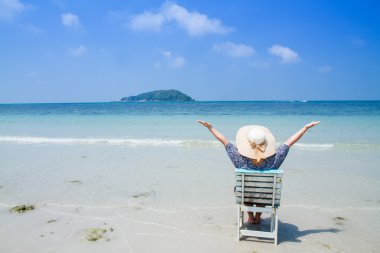 Bir yaz günü beac, zevk bir plaj sandalyesi üzerinde oturan kadın