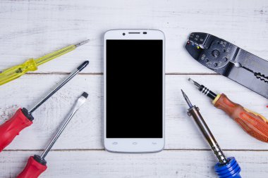 Beyaz ahşap zemin üzerinde smartphone ve donanım onarım.