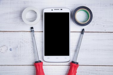 Beyaz ahşap zemin üzerinde smartphone ve donanım onarım.