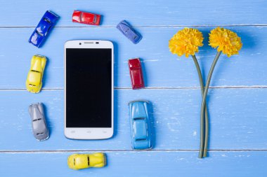 akıllı telefon, Oyuncaklar araba ve mavi ahşap bac plastik çiçekler