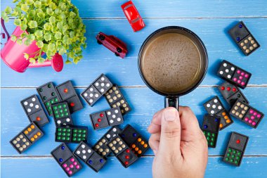 Kahve fincanı, Domino ve mavi ahşap backgr üzerinde plastik çiçekler