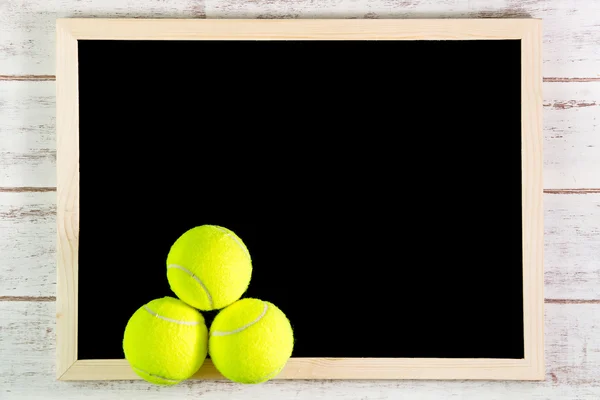 Prázdná tabule a tenisový míč na dřevěném stole. Předloha s modely u — Stock fotografie