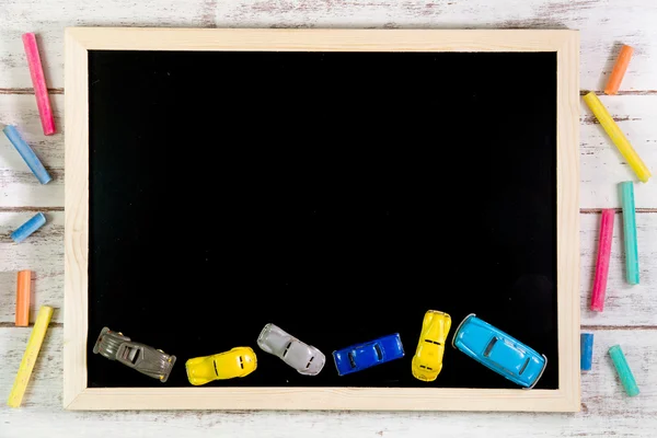 Leere Tafel und Autospielzeug auf Holztisch. — Stockfoto