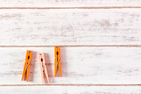 Roupa laranja peg na mesa de madeira . — Fotografia de Stock