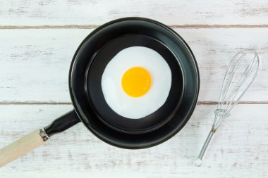 Beyaz ahşap tahta, üst VI üzerindeki kolu ile küçük tavada kızarmış yumurta