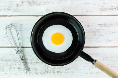 Beyaz ahşap tahta, üst VI üzerindeki kolu ile küçük tavada kızarmış yumurta