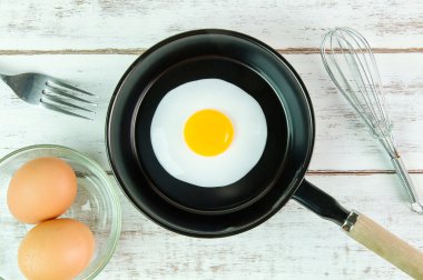 Beyaz ahşap tahta, üst VI üzerindeki kolu ile küçük tavada kızarmış yumurta