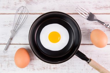 Beyaz ahşap tahta, üst VI üzerindeki kolu ile küçük tavada kızarmış yumurta