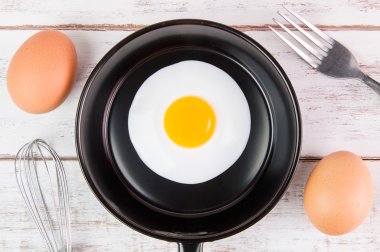 Beyaz ahşap tahta, üst VI üzerindeki kolu ile küçük tavada kızarmış yumurta