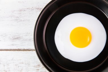 Beyaz ahşap tahta, üst VI üzerindeki kolu ile küçük tavada kızarmış yumurta