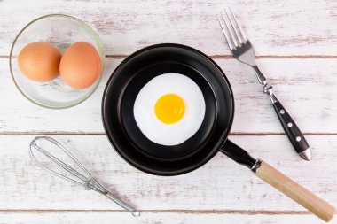 Beyaz ahşap tahta, üst VI üzerindeki kolu ile küçük tavada kızarmış yumurta