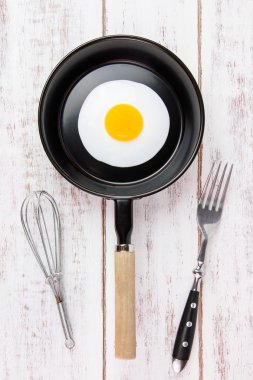 Beyaz ahşap tahta, üst VI üzerindeki kolu ile küçük tavada kızarmış yumurta