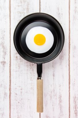 Beyaz ahşap tahta, üst VI üzerindeki kolu ile küçük tavada kızarmış yumurta