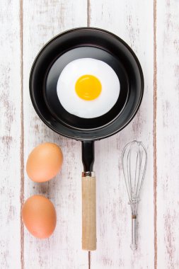 Beyaz ahşap tahta, üst VI üzerindeki kolu ile küçük tavada kızarmış yumurta