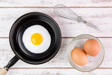 Beyaz ahşap tahta, üst VI üzerindeki kolu ile küçük tavada kızarmış yumurta