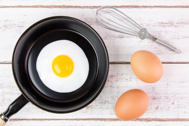 Beyaz ahşap tahta, üst VI üzerindeki kolu ile küçük tavada kızarmış yumurta