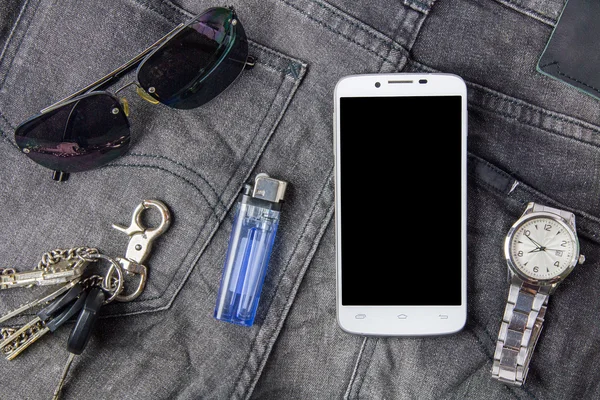 Smartphone, Sonnenbrille und Uhr auf Jeans-Hintergrund — Stockfoto