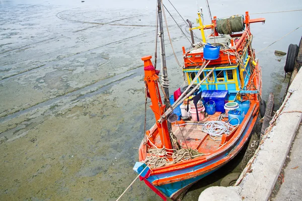 Рыбацкая лодка села на мель на рыболовецком пирсе во время отлива — стоковое фото