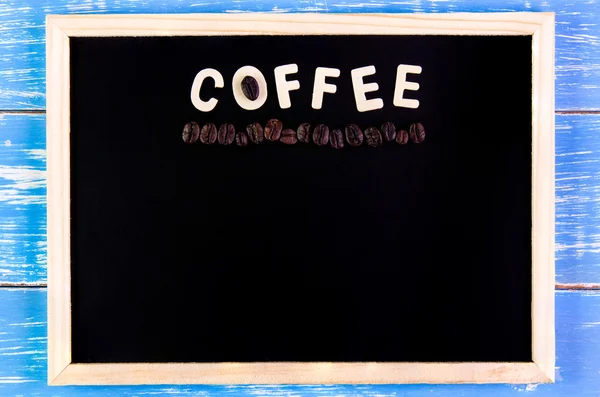 Drewniany angielski alfabet kawy i ziarna kawy na tablicy — Zdjęcie stockowe